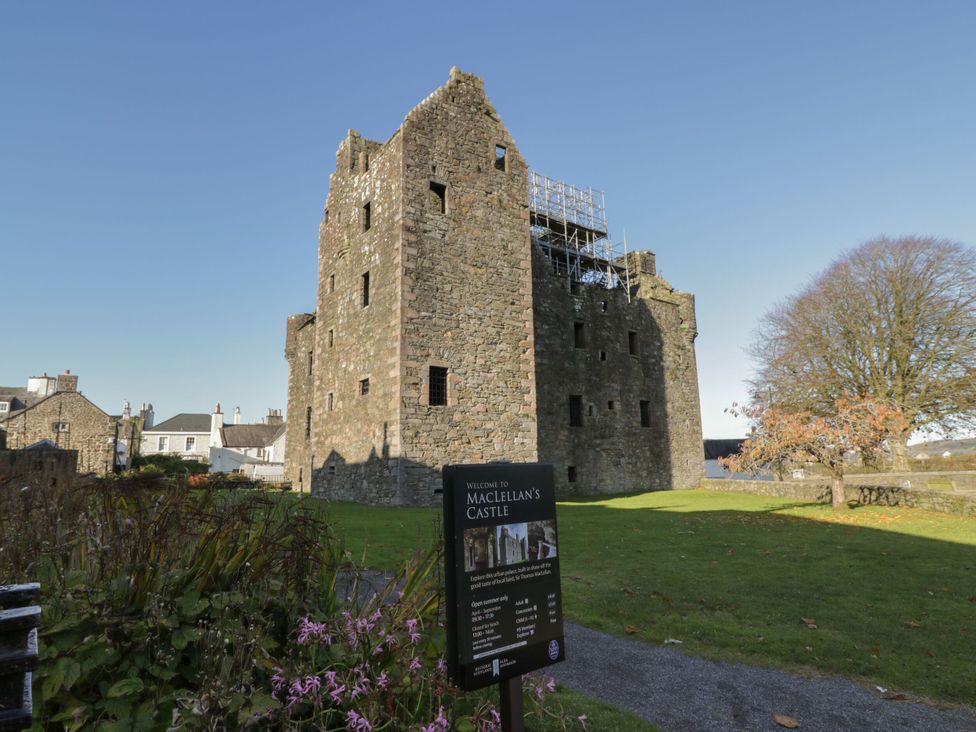 A castle with scaffolding and a welcome sign at MacLellan's Castle in Kirkcudbright