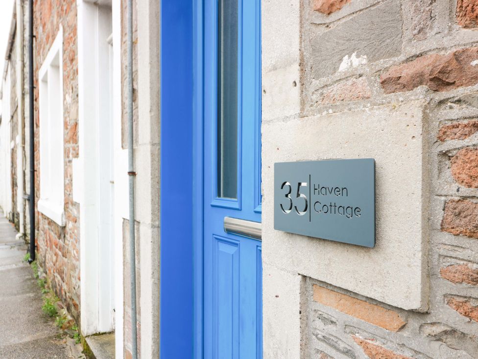 A blue door with a house number sign at Haven Cottage in Kirkcudbright
