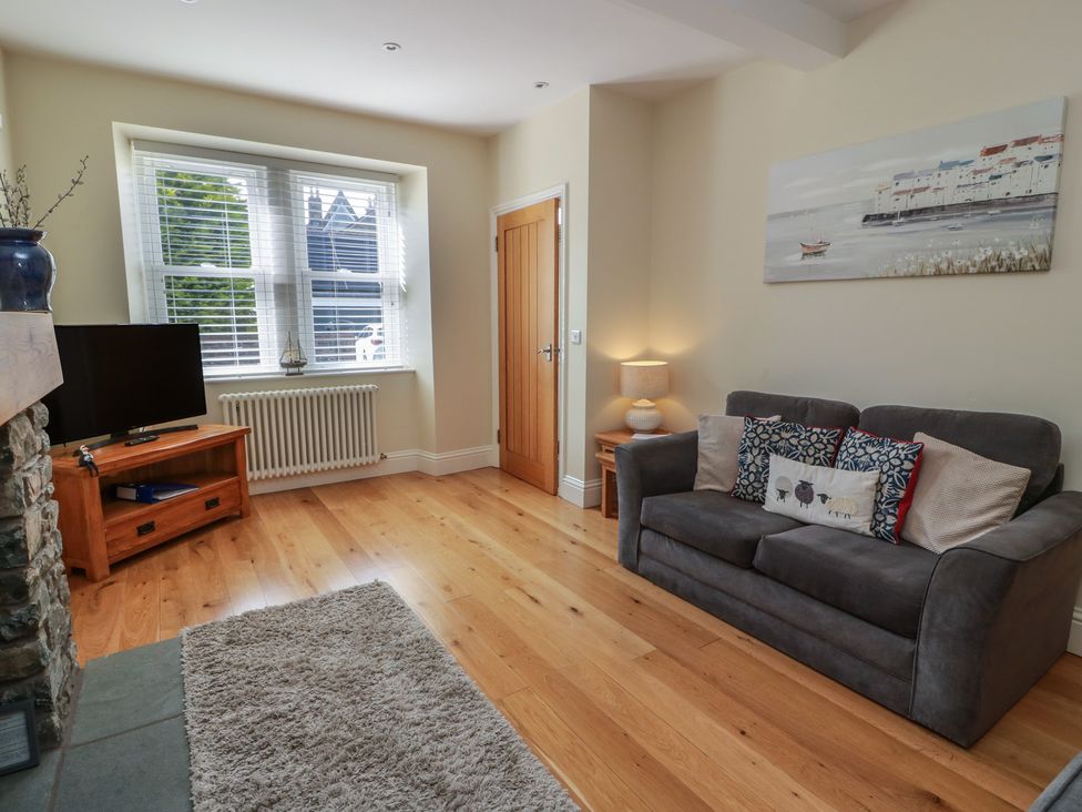 A living room with a sofa and television at Haven Cottage in Kirkcudbright