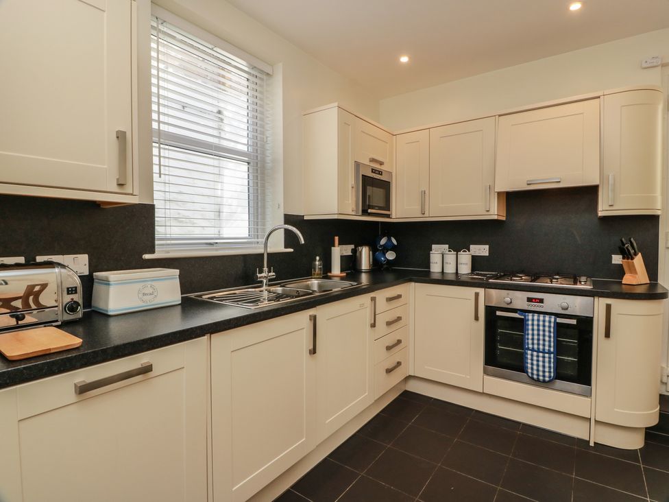 A kitchen with appliances and storage cabinets at Haven Cottage in Kirkcudbright