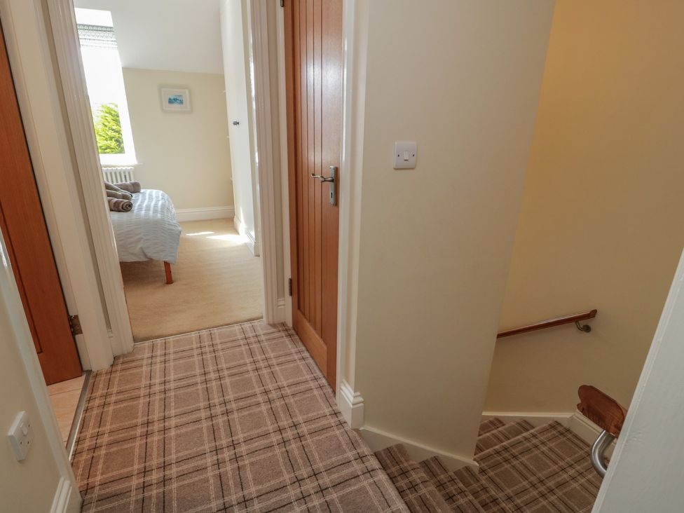 A hallway leading to a room with a window at Haven Cottage in Kirkcudbright