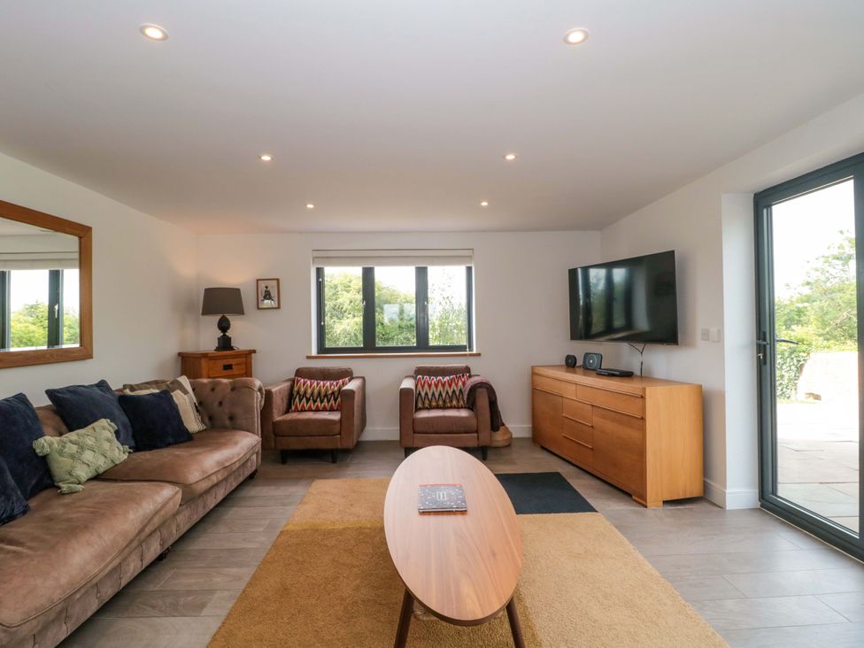 A living room with a sofa and television at Station House Bason Bridge near Highbridge