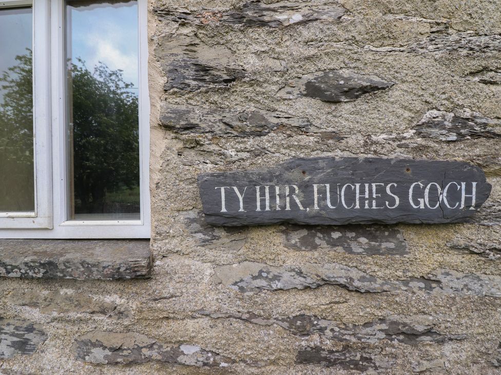 Window with a slate sign on stone wall at The Long House in Penmachno