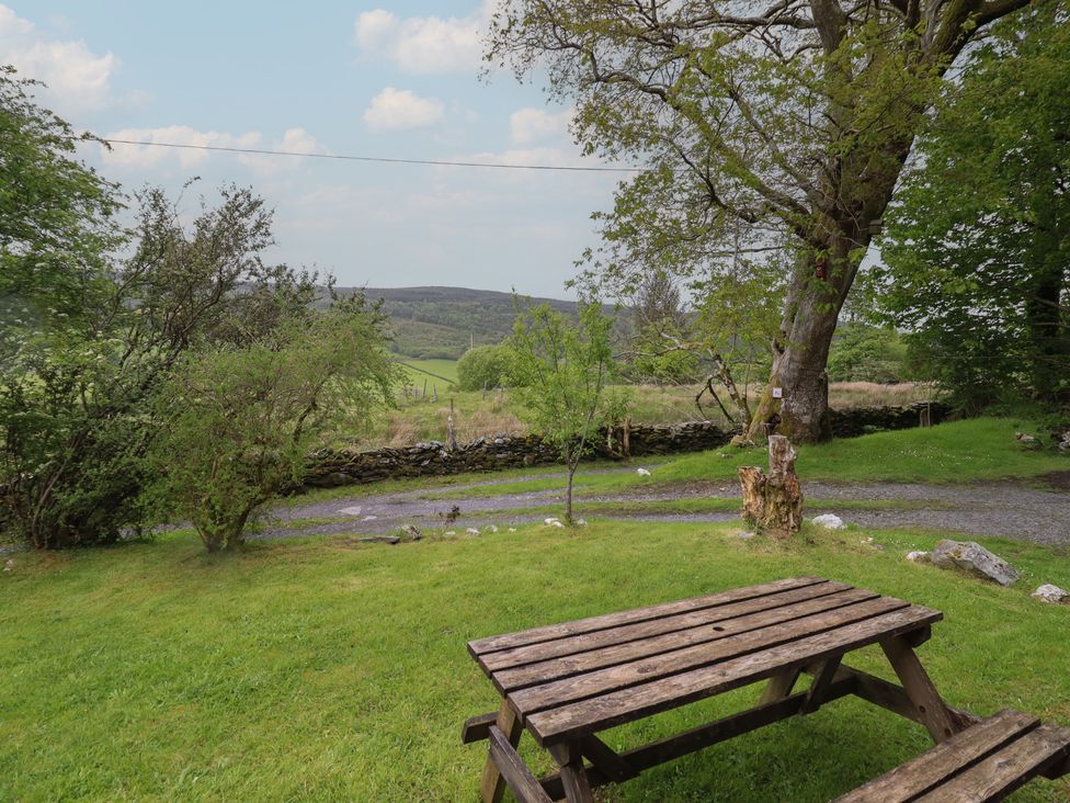 A picnic table in a garden area at The Long House in Penmachno