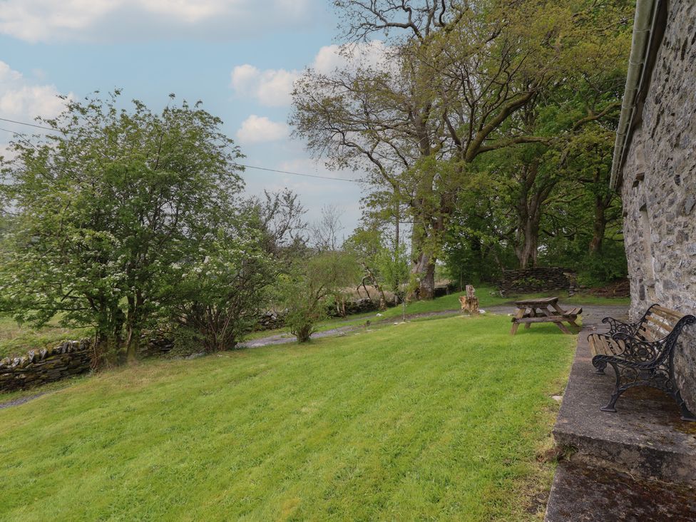 An outdoor area with a bench and picnic table at The Long House in Penmachno