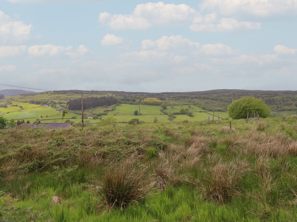 A landscape with fields and hills at The Long House in Penmachno