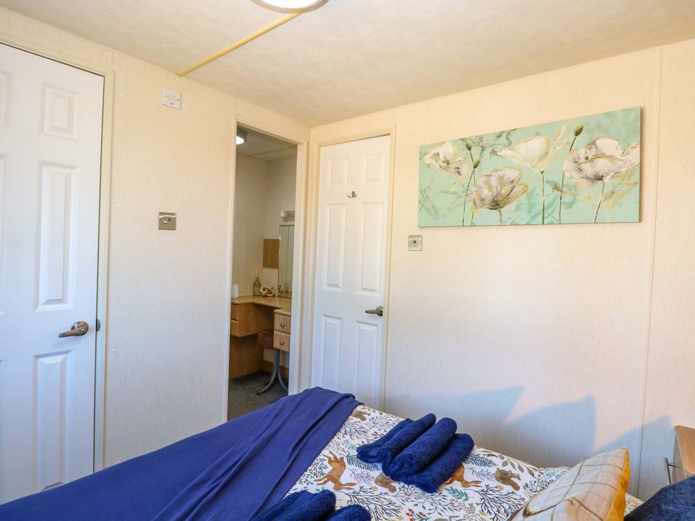 A bedroom with a bed and a vanity at 25 Foxburrow Hang in Fritton near Belton