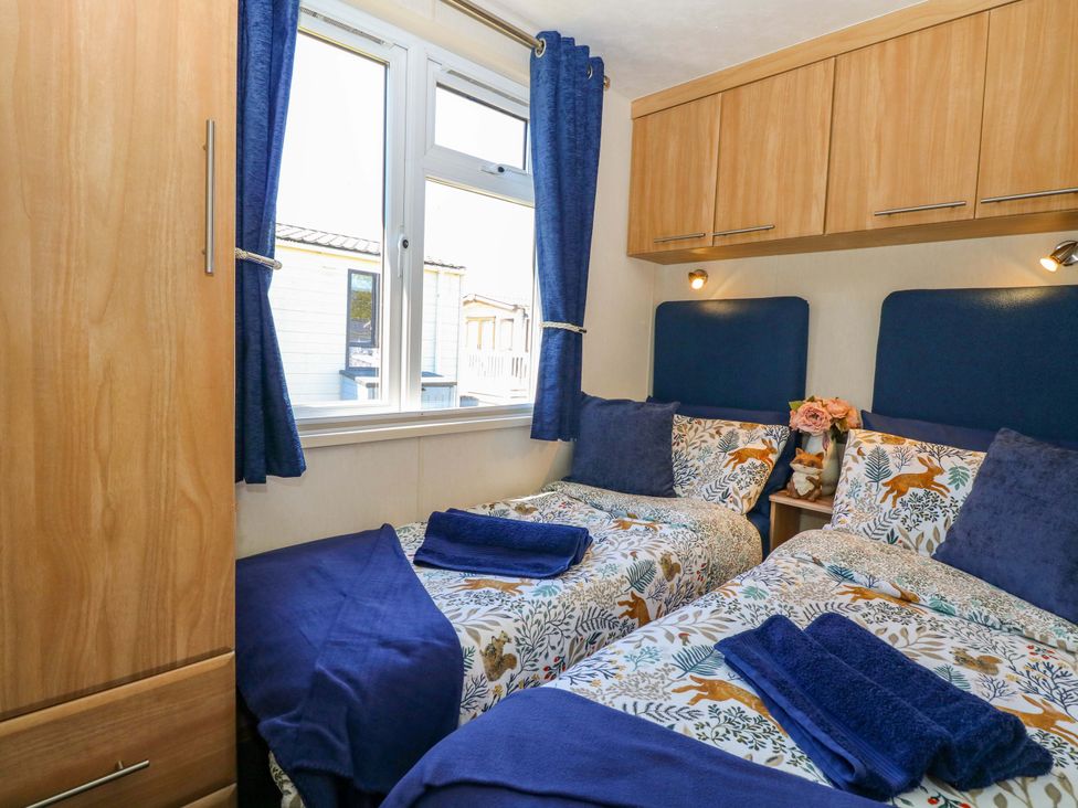 A bedroom with two beds and a window at 25 Foxburrow Hang in Fritton near Belton