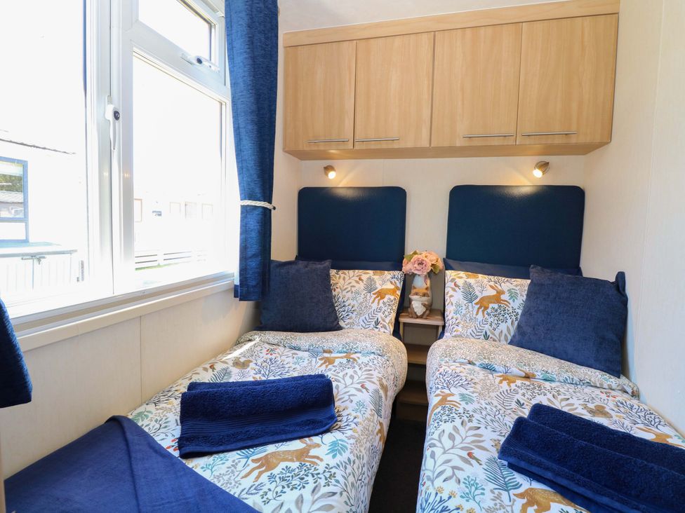A bedroom with two beds and a flower vase at 25 Foxburrow Hang in Fritton near Belton