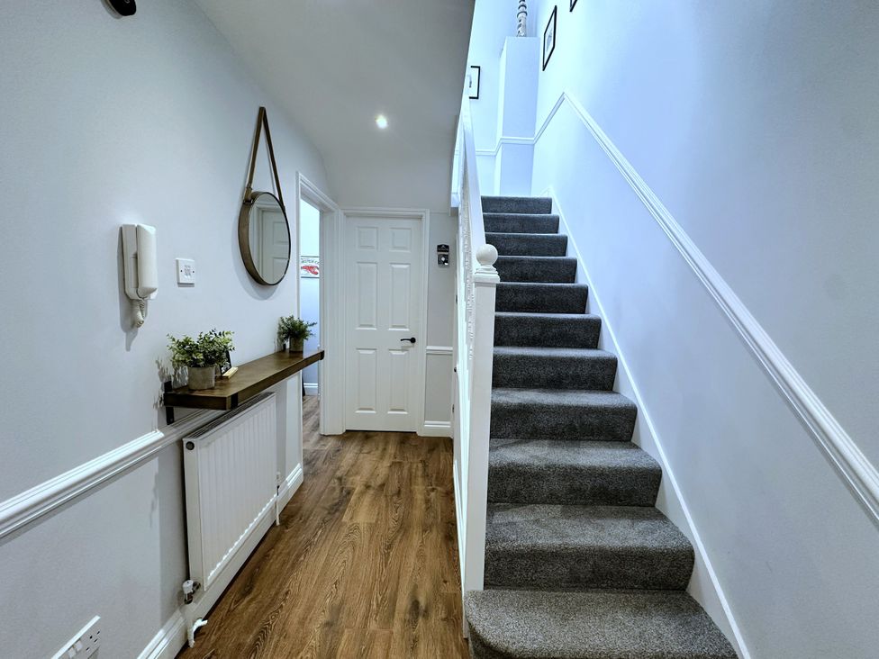 A hallway with a staircase and a plant at Melanie's Cottage Brewers Quay Harbour
