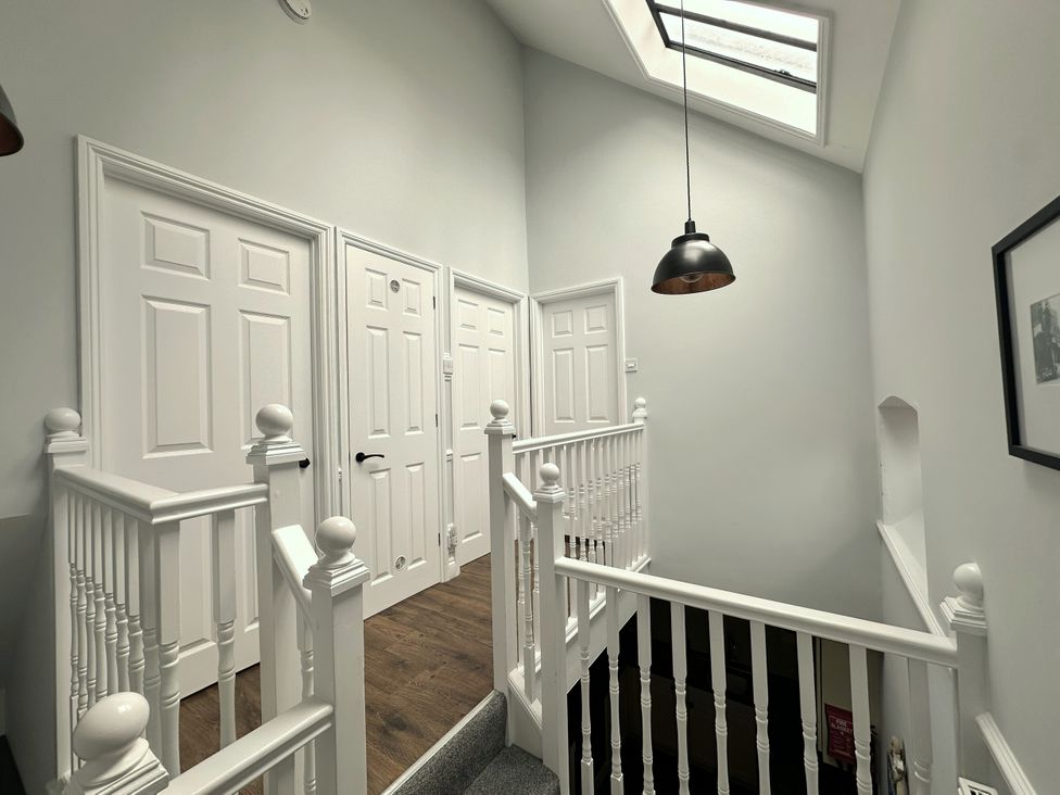 A hallway with stairs and doors at Melanie's Cottage Brewers Quay Harbour