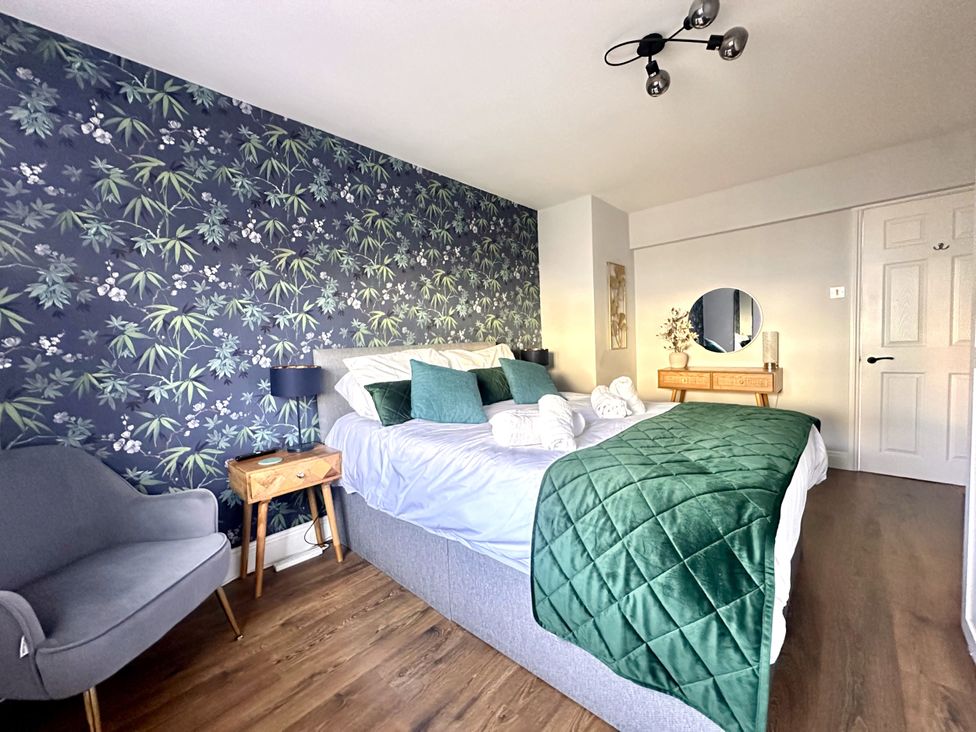 A bedroom with a bed and mirror at Melanie's Cottage in Brewers Quay Harbour