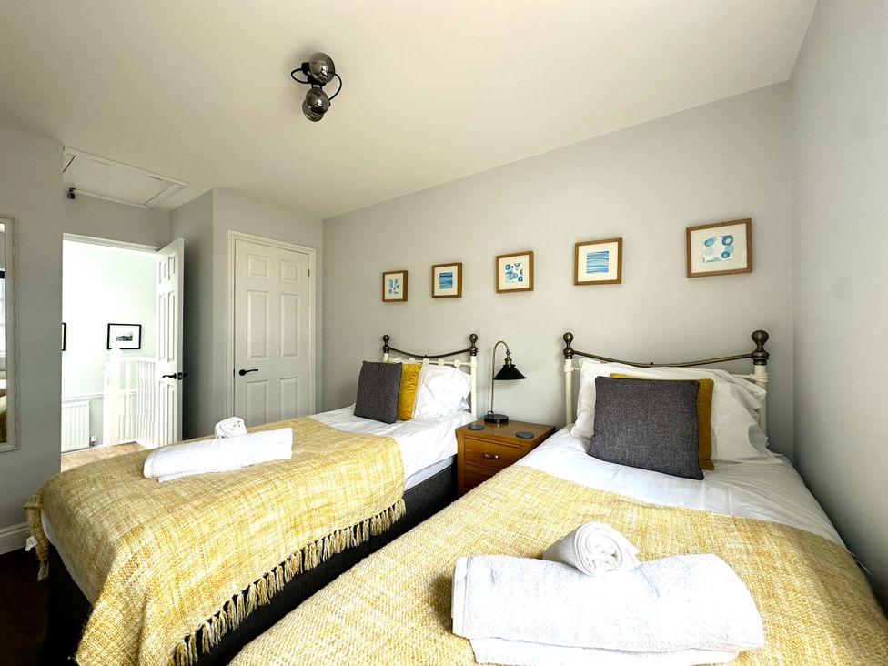 A bedroom with two beds and a mirror at Melanie's Cottage in Brewers Quay Harbour