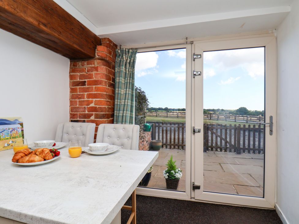 A dining room with a table and chairs at Hawthorn Cottage Silpho near Scalby