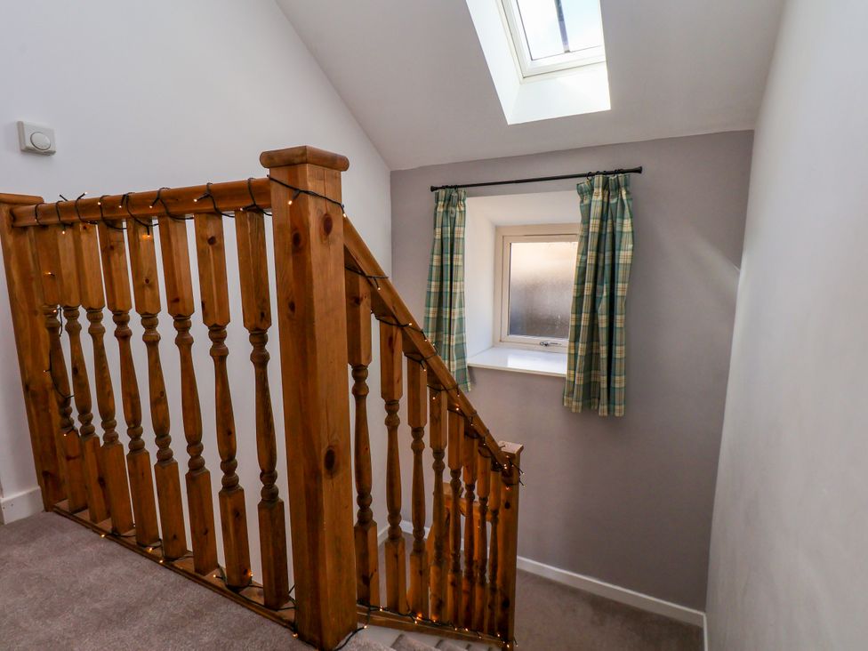 A staircase with a railing and window at Hawthorn Cottage in Silpho near Scalby
