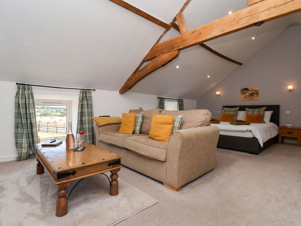 A bedroom with a sofa and coffee table at Hawthorn Cottage Silpho near Scalby