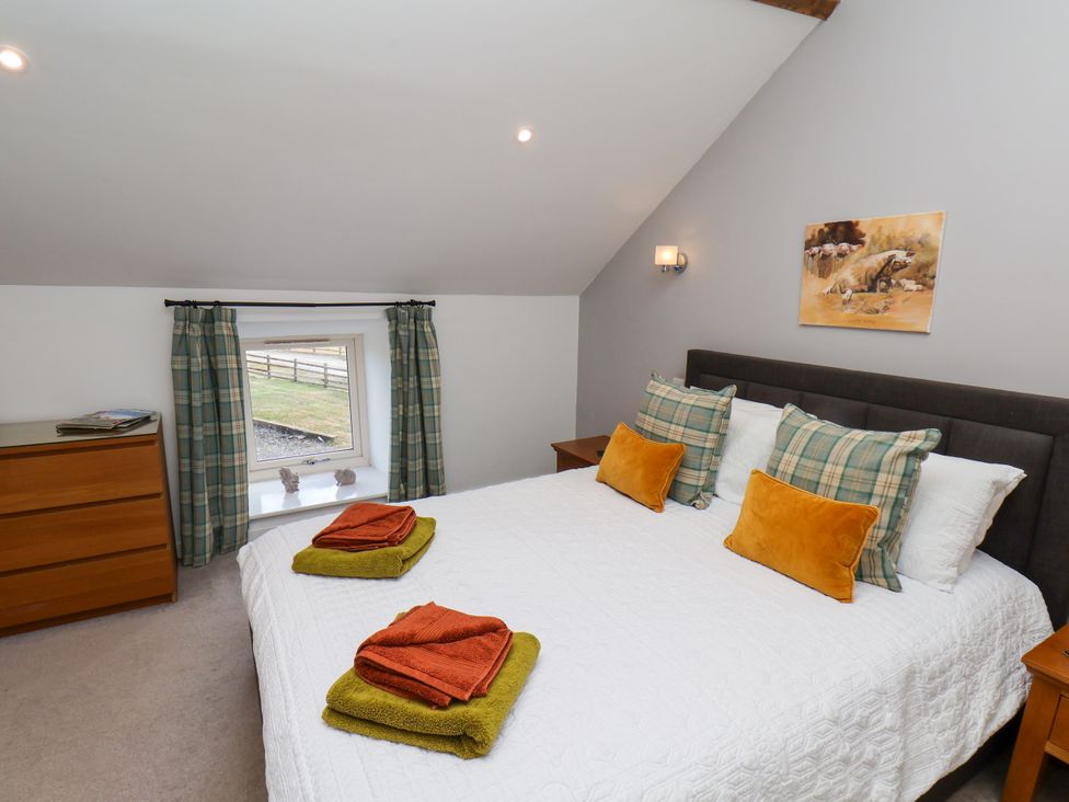 A bedroom with a bed and drawers at Hawthorn Cottage in Silpho near Scalby