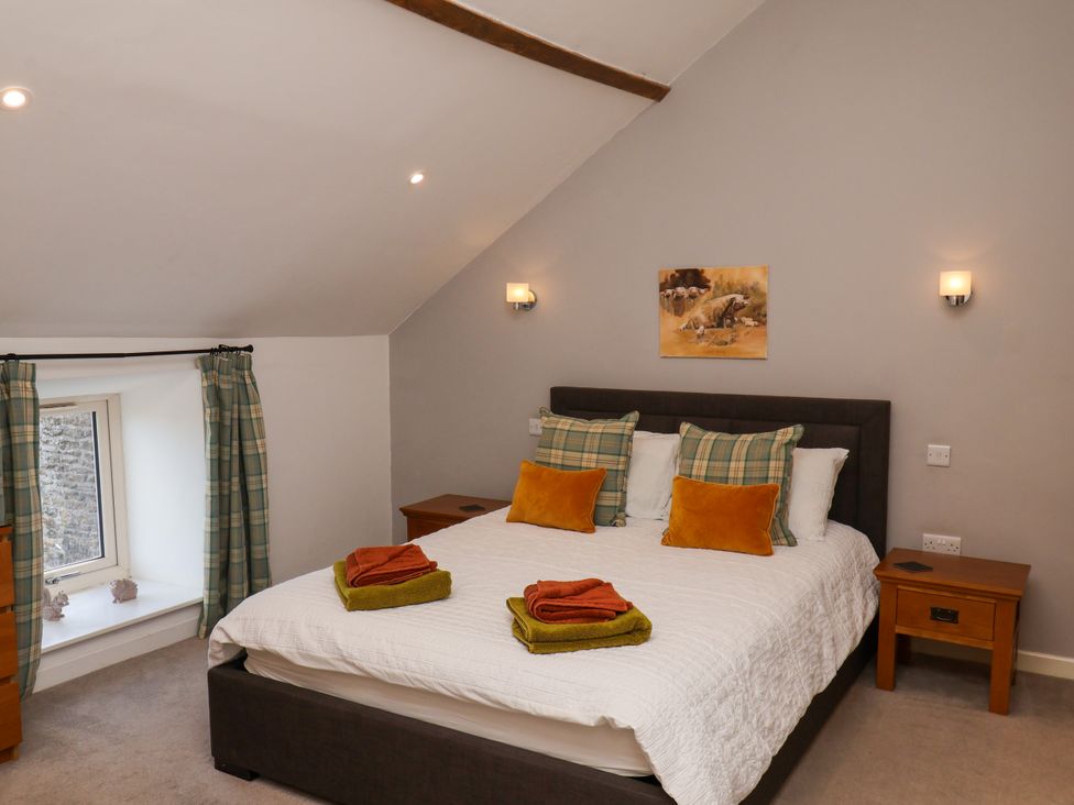 A bedroom with a bed and window at Hawthorn Cottage in Silpho near Scalby