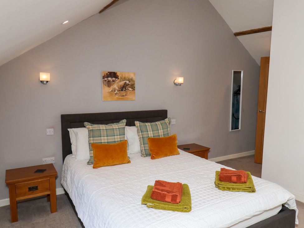 A bedroom with a double bed and bedside table at Hawthorn Cottage in Silpho near Scalby