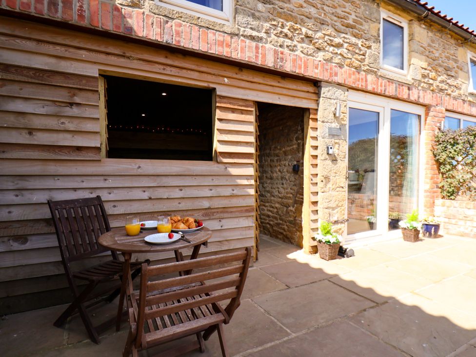 An outdoor area with a table and chairs at Hawthorn Cottage in Silpho near Scalby