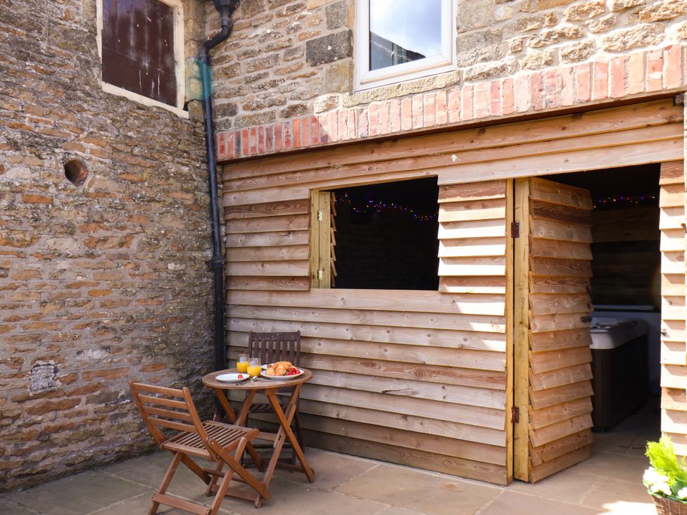 An outdoor area with a table and wooden stools at Hawthorn Cottage in Silpho near Scalby