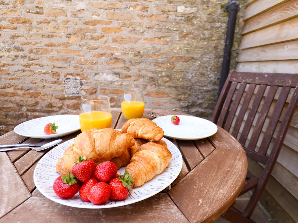 A table with croissants and strawberries at Hawthorn Cottage in Silpho near Scalby