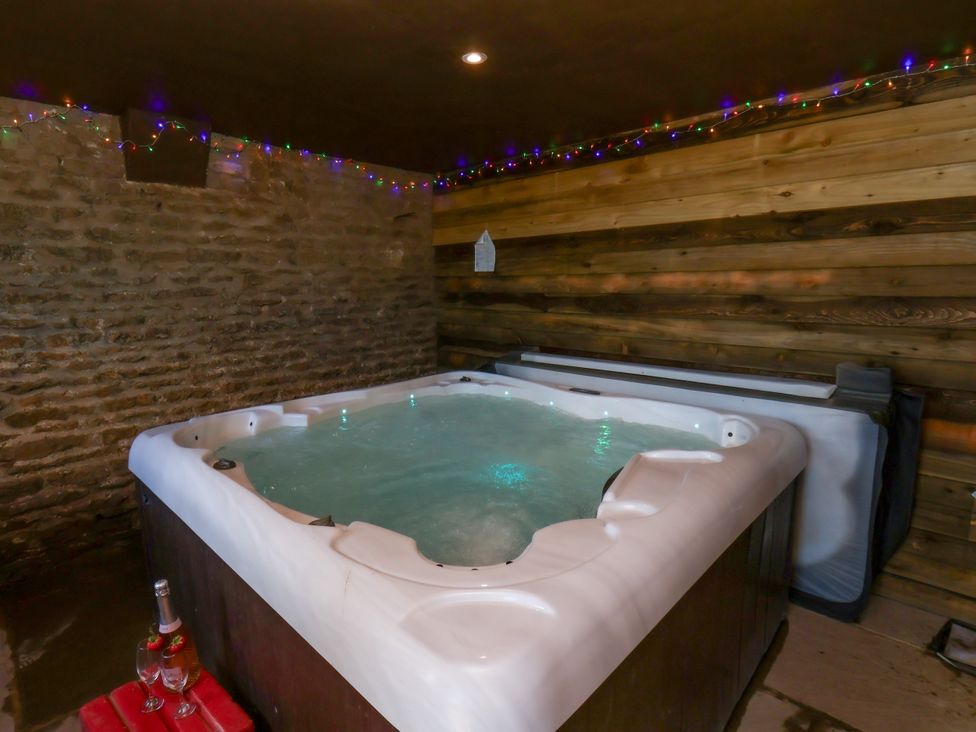 A hot tub in a wooden and stone interior at Hawthorn Cottage Silpho near Scalby