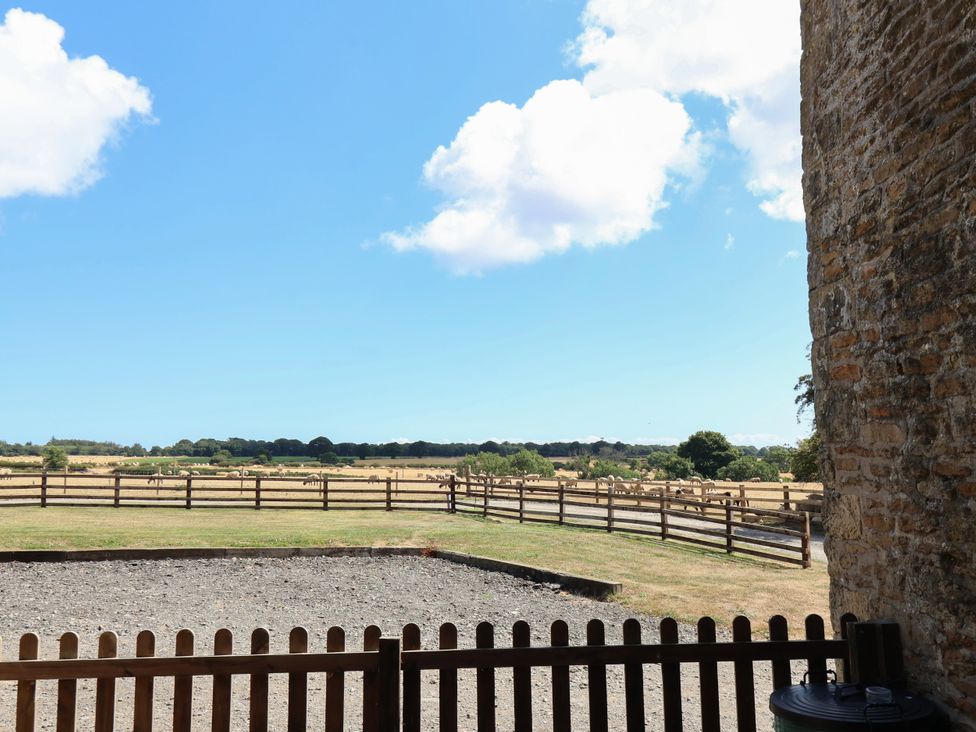 A view of a field with a fence and dirt area at Hawthorn Cottage Silpho near Scalby