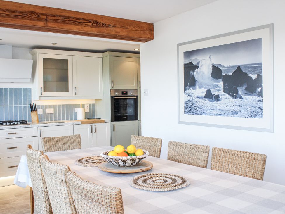 A dining room with a table and fruit bowl at Firm Anchor in Salcombe