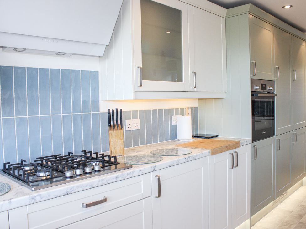 A kitchen with a gas stove and knife block at Firm Anchor in Salcombe