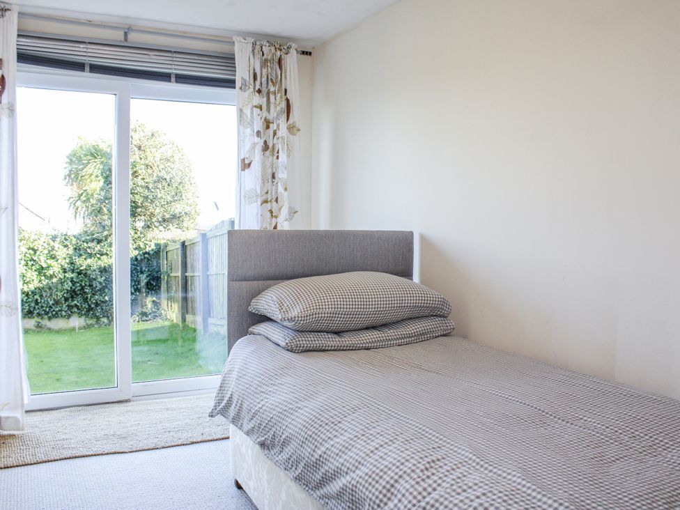 A bedroom with a bed and open window at Firm Anchor in Salcombe