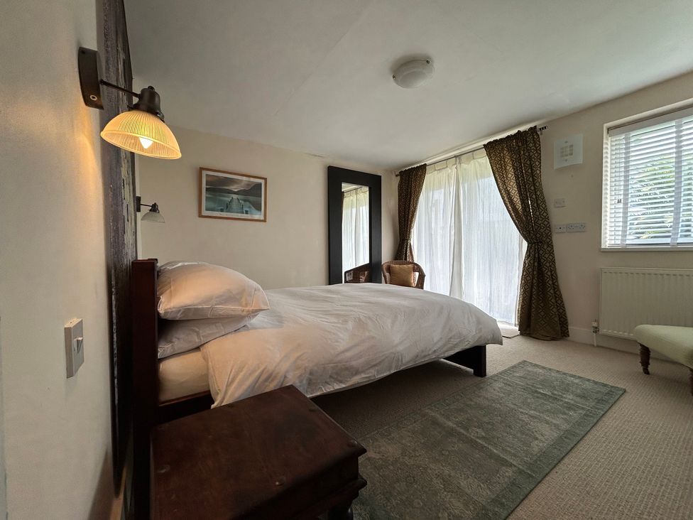 A bedroom with a bed and mirror at Firm Anchor in Salcombe
