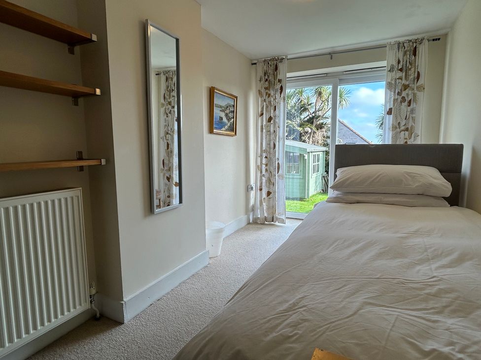 A bedroom with a bed and shelves at Firm Anchor in Salcombe