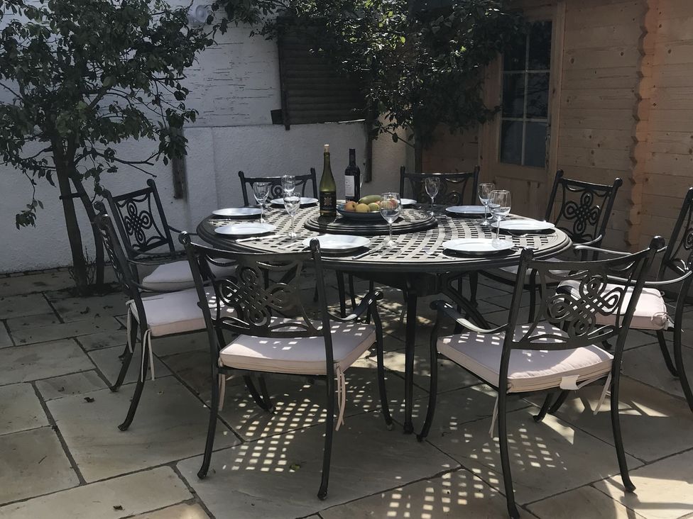 A dining table set with wine and fruit at Firm Anchor in Salcombe