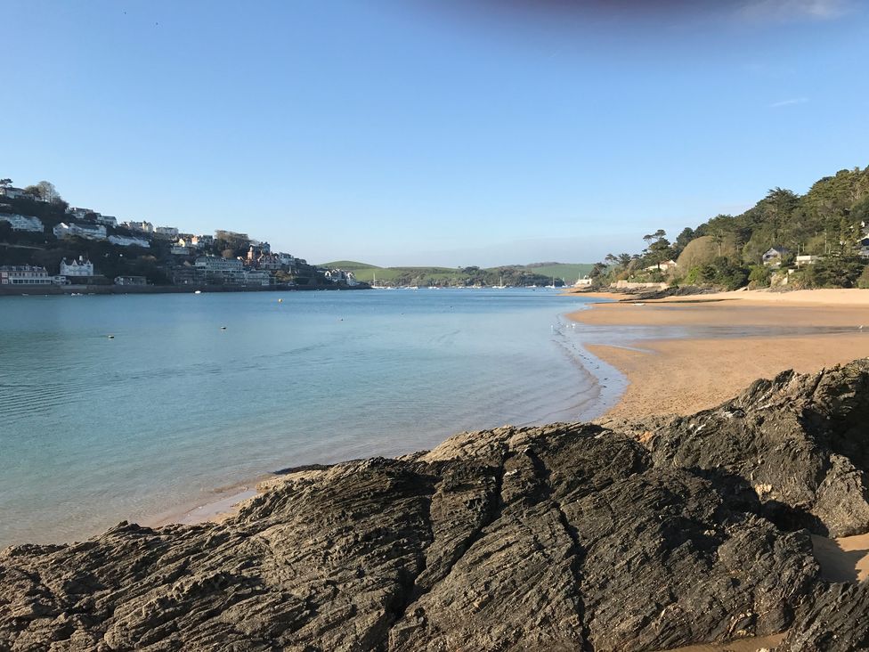 A view of a beach with water and rocks at Firm Anchor in Salcombe