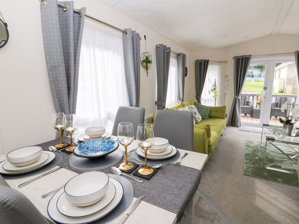 A living room with a dining area and green couch at The Haven in 