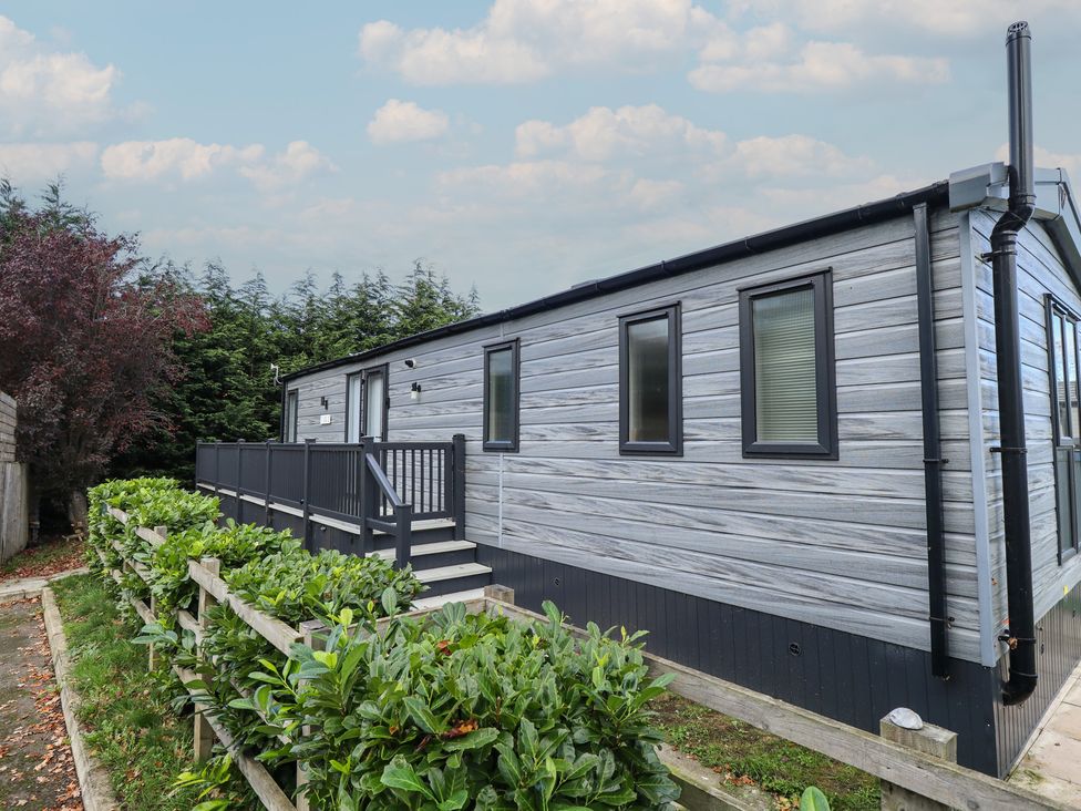 A mobile home with a deck and steps at Heather William Lodge near Woodhall Spa