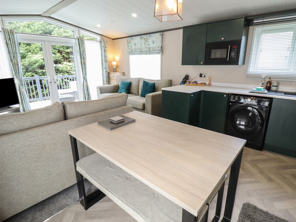 A living room with a sofa and dining table at Heather William Lodge near Woodhall Spa