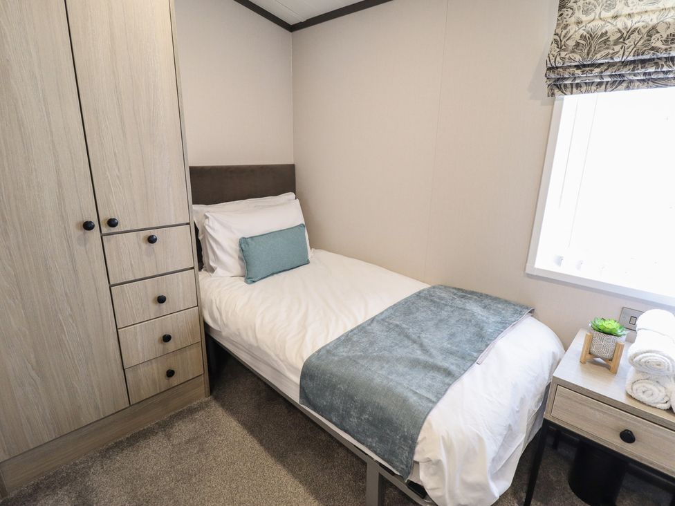 A bedroom with a single bed and wardrobe at Heather William Lodge near Woodhall Spa