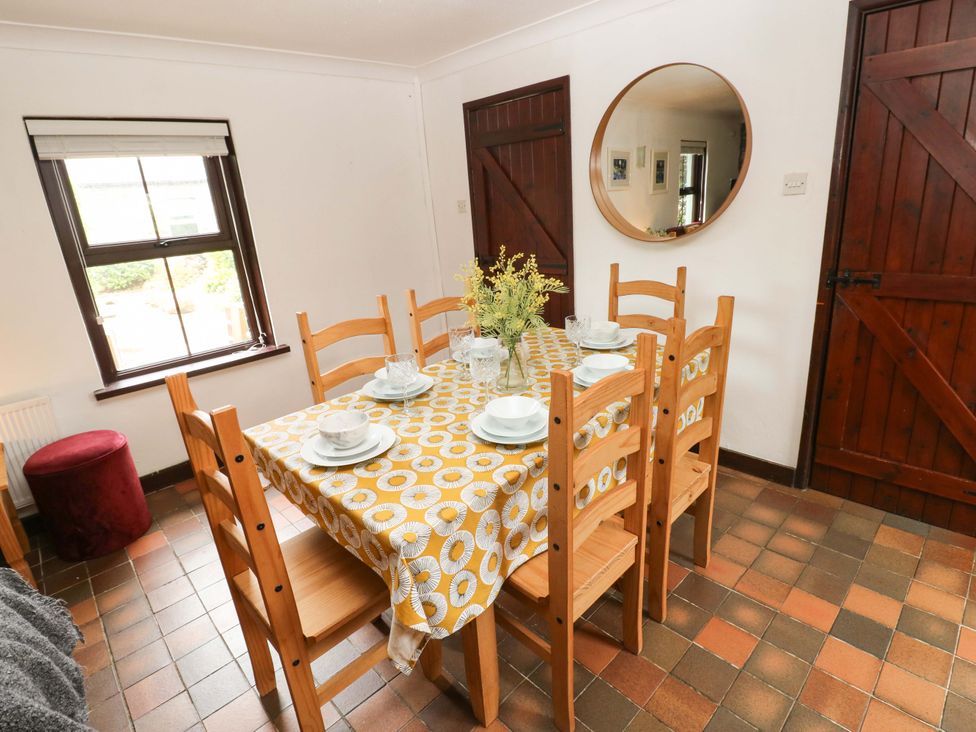 A dining room with a table and chairs at The Coach House in Broad Haven