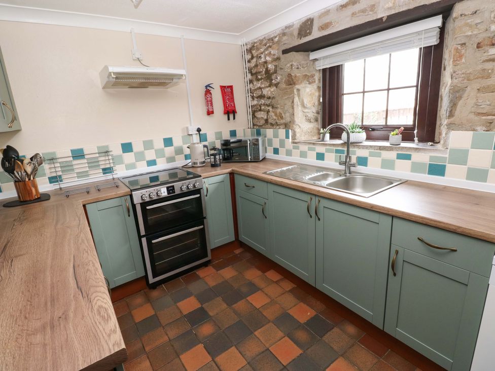 A kitchen with cabinets and appliances at The Coach House in Broad Haven