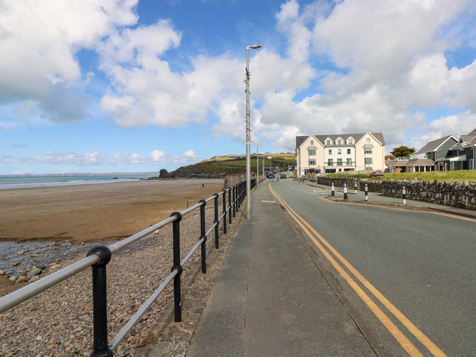 A beach view with a road and buildings at The Coach House in Broad Haven