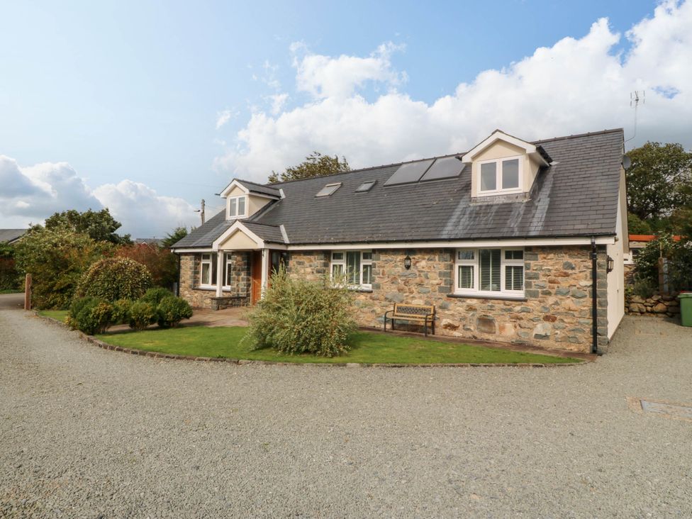 A house with a garden and gravel driveway at Ty Ni in Dyffryn Ardudwy