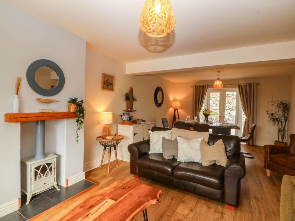 A living room with a sofa and dining area at Ty Ni in Dyffryn Ardudwy