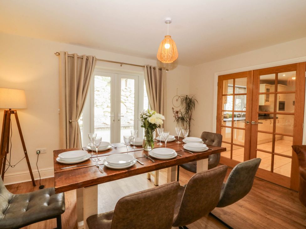 A dining room with a wooden table and chairs at Ty Ni in Dyffryn Ardudwy