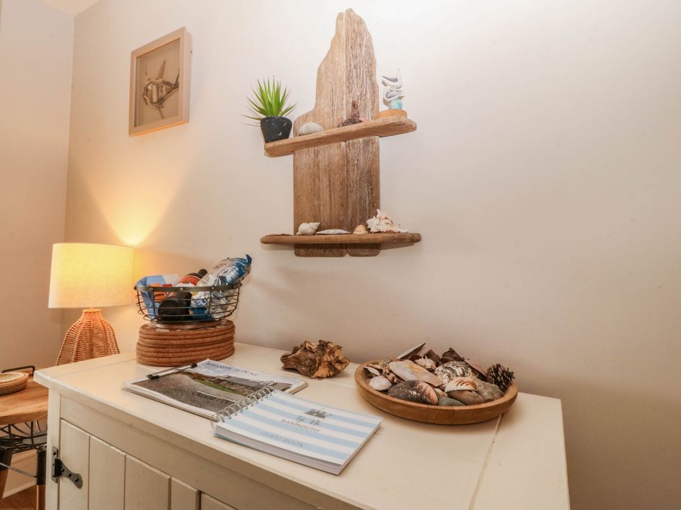 A decorative shelf with seashells and a lamp at Ty Ni in Dyffryn Ardudwy
