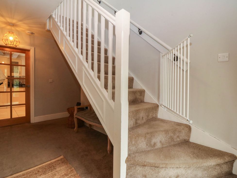A staircase with a safety gate and door in a hallway at Ty Ni in Dyffryn Ardudwy