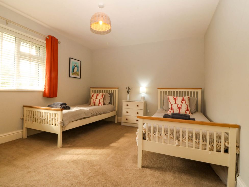 A bedroom with two single beds and a dresser at Ty Ni in Dyffryn Ardudwy