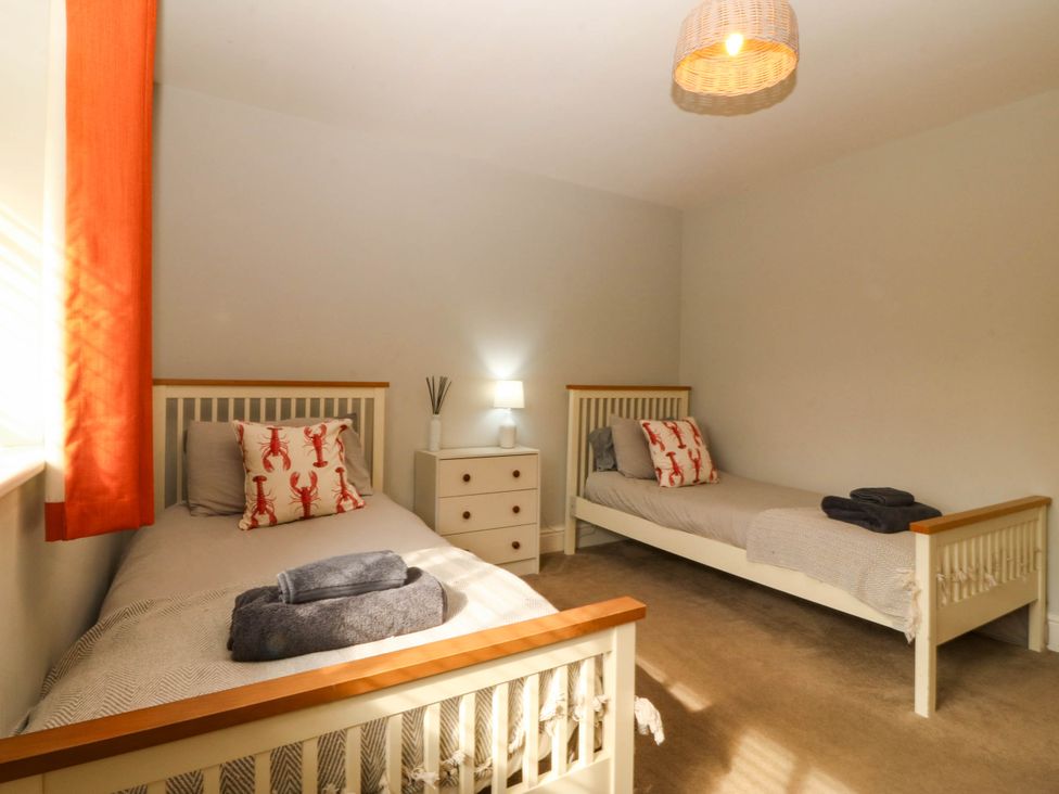 A bedroom with two single beds and a bedside table at Ty Ni in Dyffryn Ardudwy