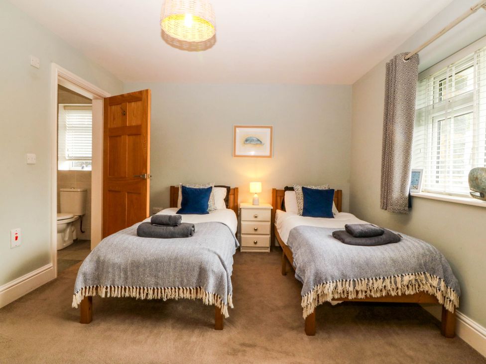 A bedroom with twin beds and a bedside table at Ty Ni Dyffryn Ardudwy